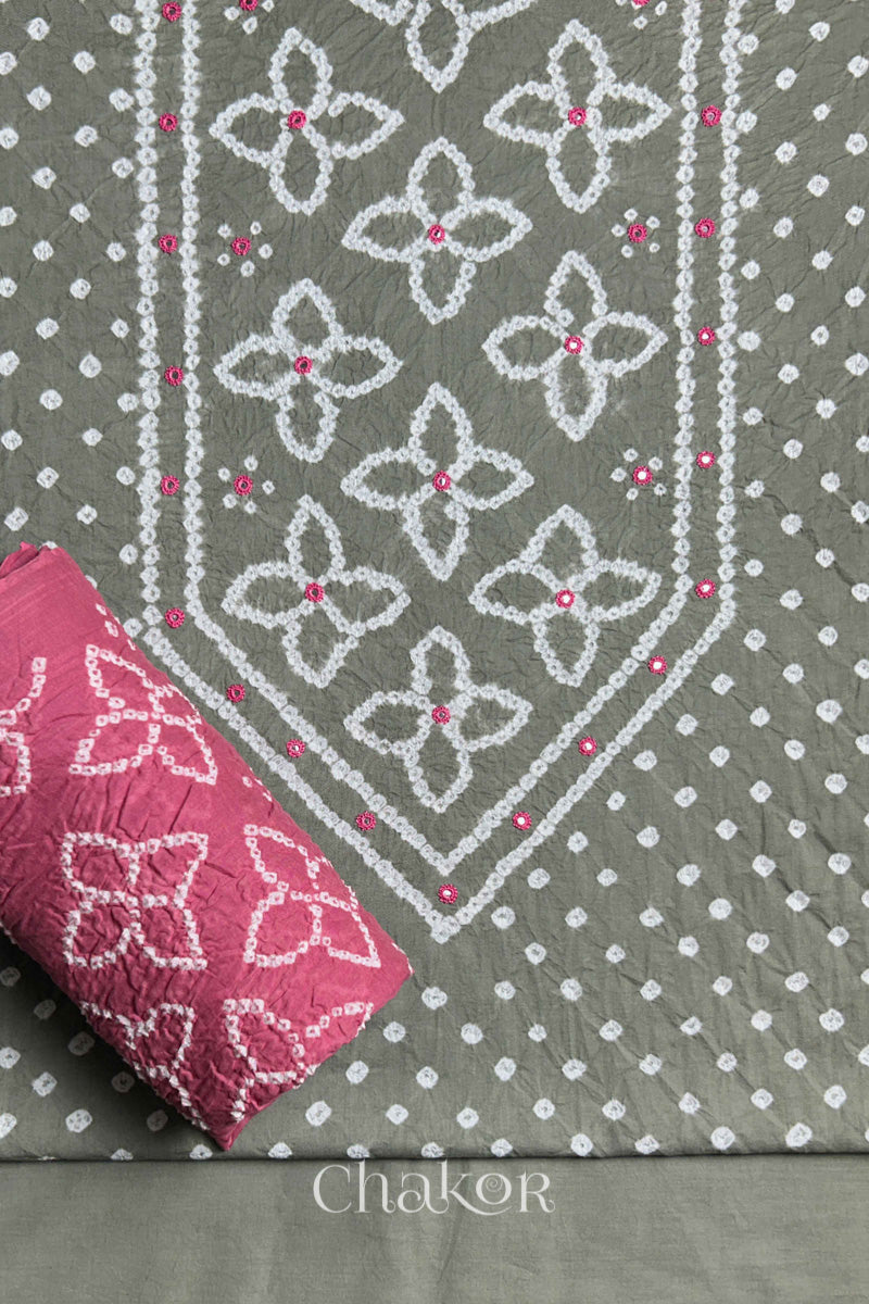 Front yoke detail of Grey Bandhani cotton kurta fabric with hand embroidery and mirror work and Rose Pink dupatta rolled up.

