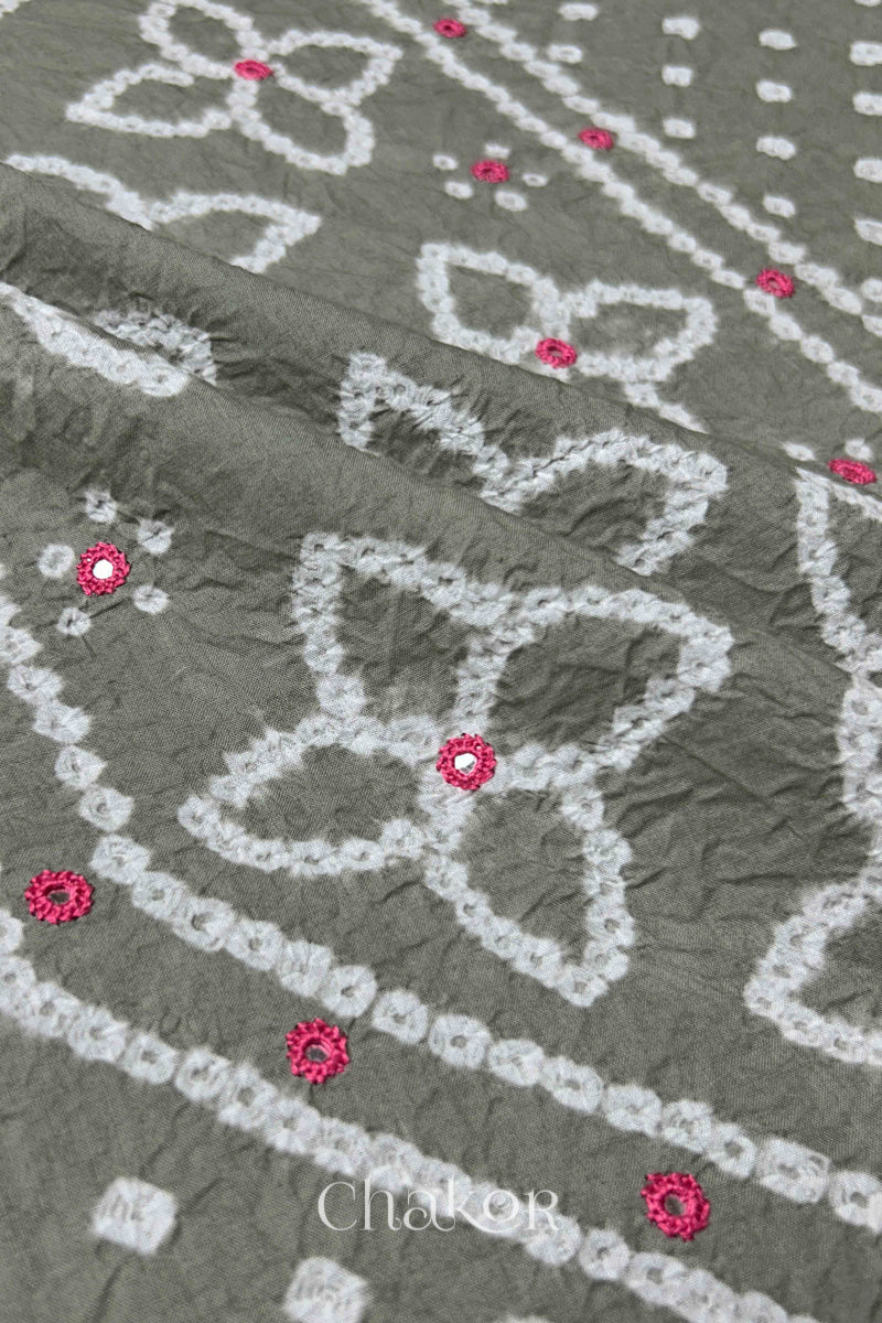 Hand tied Bandhani floral motif with colourful mirror embroidery on Grey cotton fabric.
