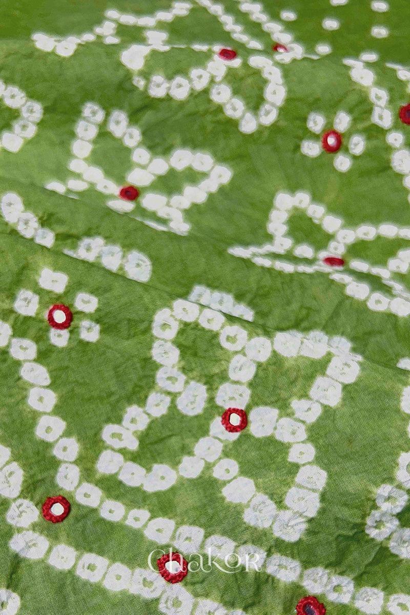 Hand tied Bandhani floral motif with colourful mirror embroidery on Green cotton fabric.
