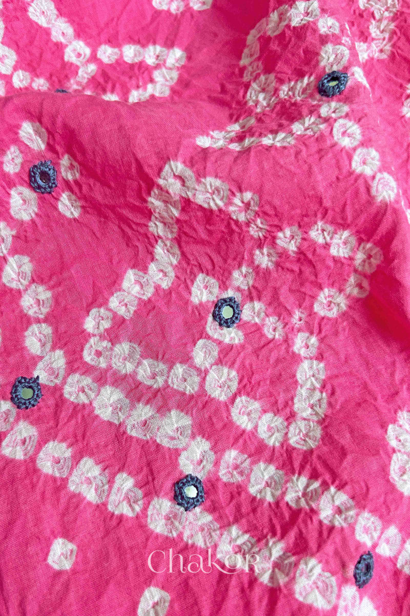 Hand tied Bandhani floral motif with colourful mirror embroidery on Pink cotton fabric.
