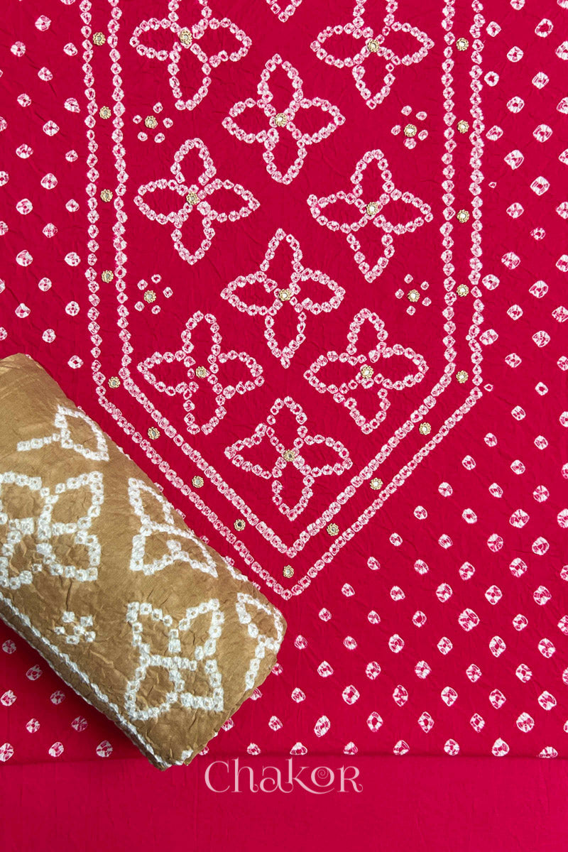 Front yoke detail of Strawberry Pink Bandhani cotton kurta fabric with hand embroidery and mirror work and Beige dupatta rolled up.
