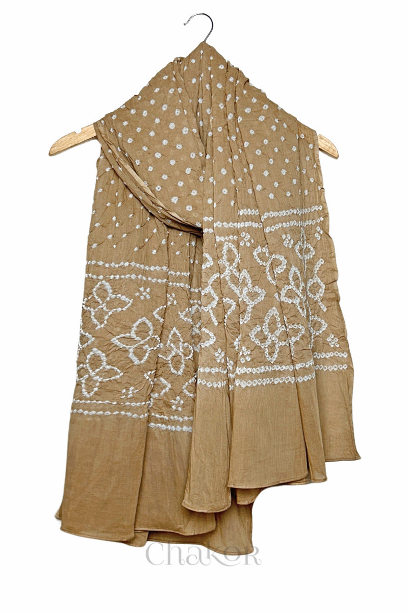 Beige mercerised mulmul cotton dupatta with Bandhani floral pallu design draped on hanger.
