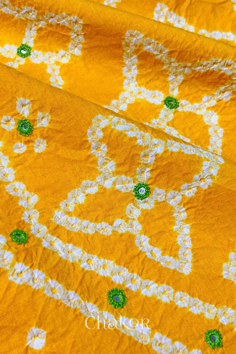 Close-up of Bandhani floral pattern accented with hand embroidery Yellow mirror work.
