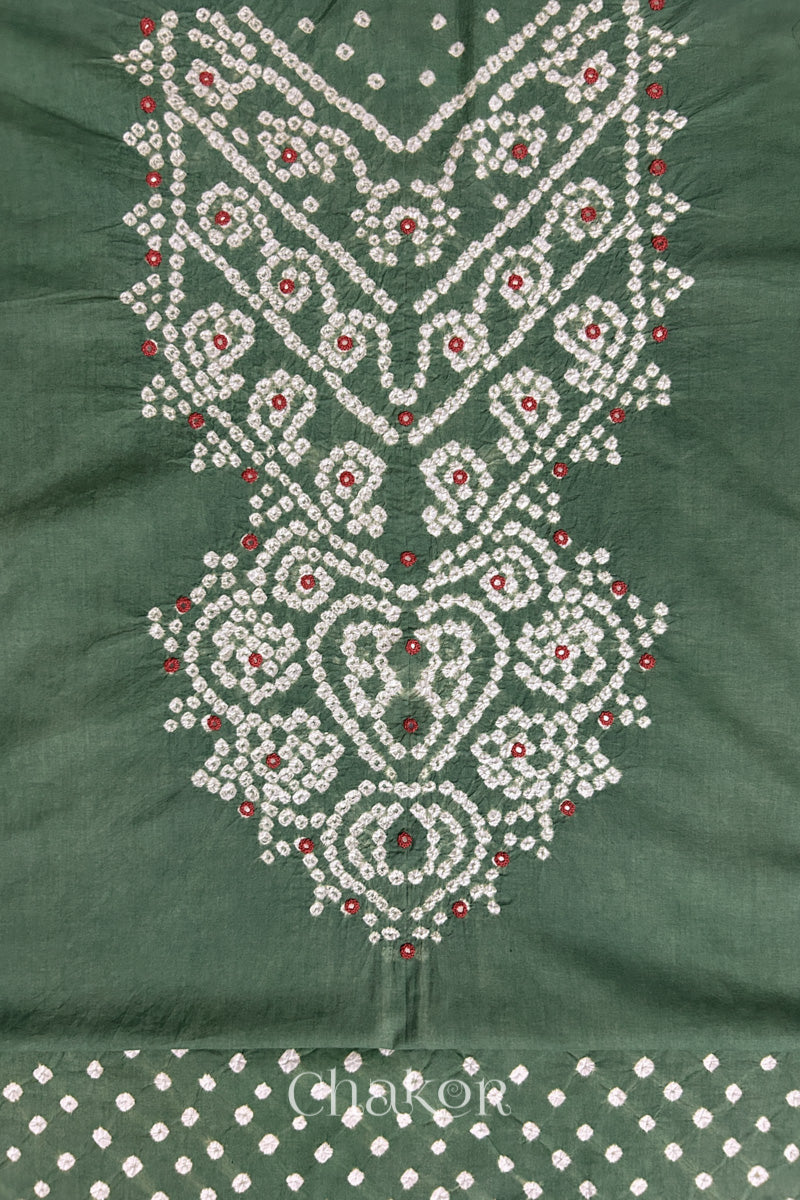 Close-up of tie dyed moss green kurta fabric featuring intricate bandhani and embroidered patterns with matching bandhani dotted bottom fabric, with Chakor brand logo.
