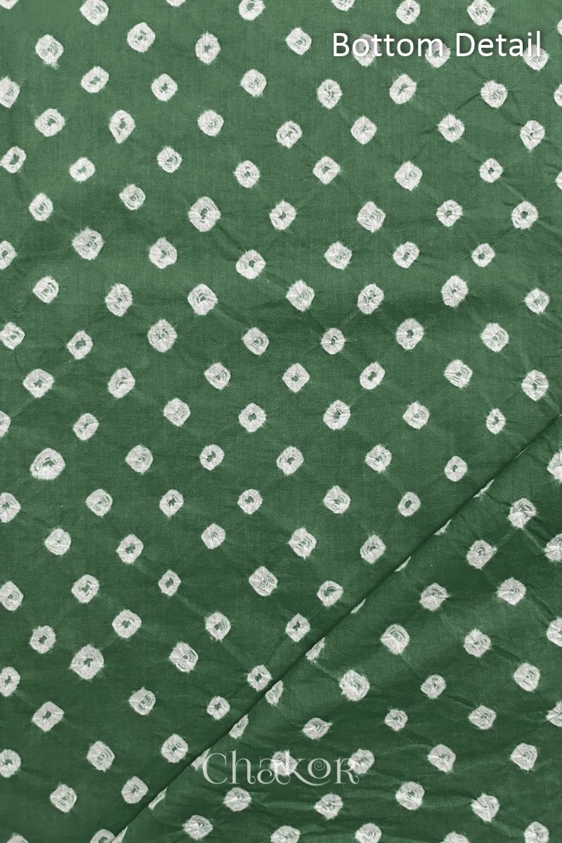 Close up of bottom fabric in  moss green patterned with bandhani tie dye dots, folded at the corner displaying texture and detail. Text reads bottom.