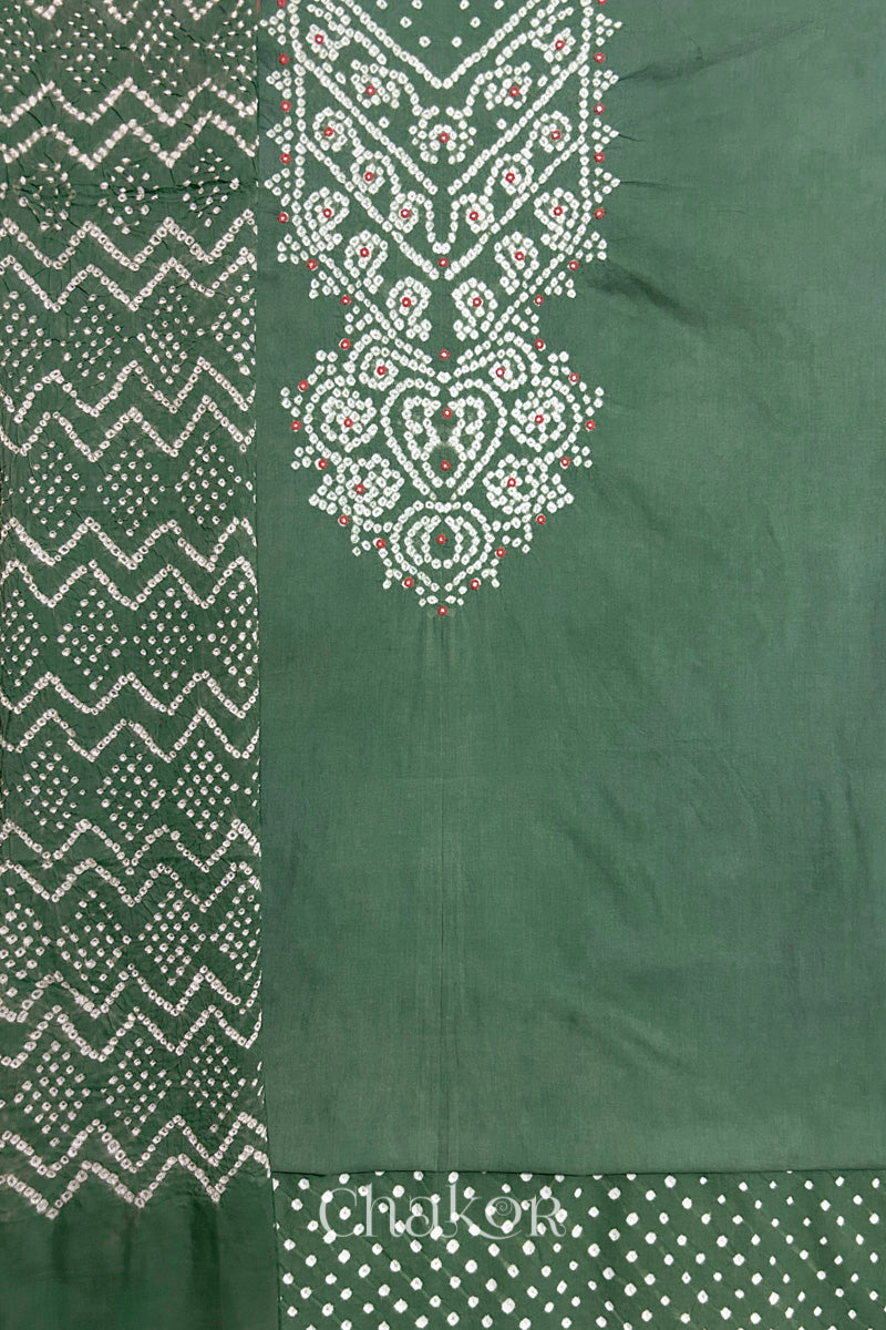 A  moss green kurta set fabric with intricate bandhani & mirror embroidered yoke, paired with a matching bottom & odhani placed on the left side featuring a zigzag design.

