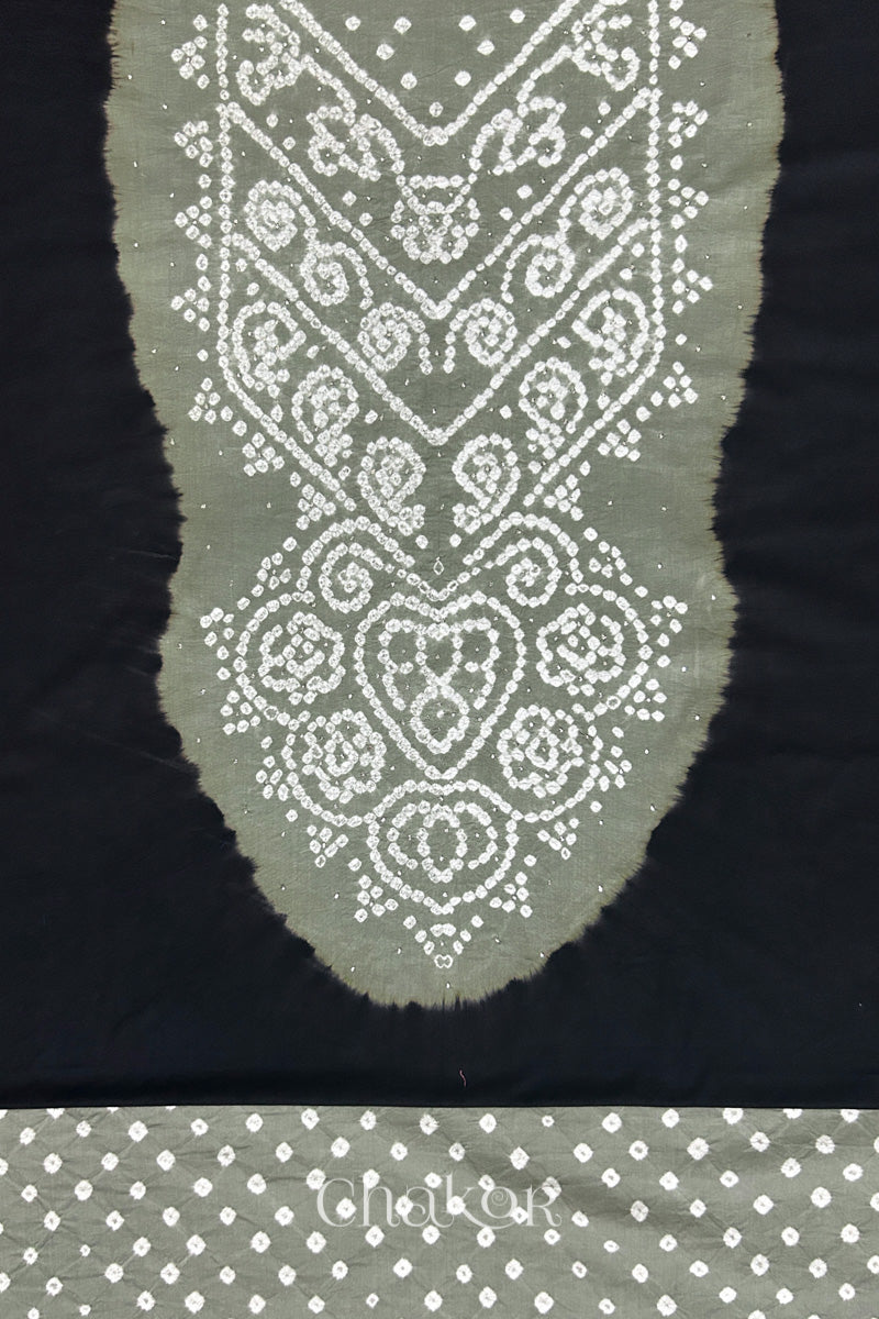 Close-up of black kurta fabric featuring intricate bandhani & cement grey mukaish embroidered yoke with bandhani dotted bottom fabric, with Chakor brand watermark.
