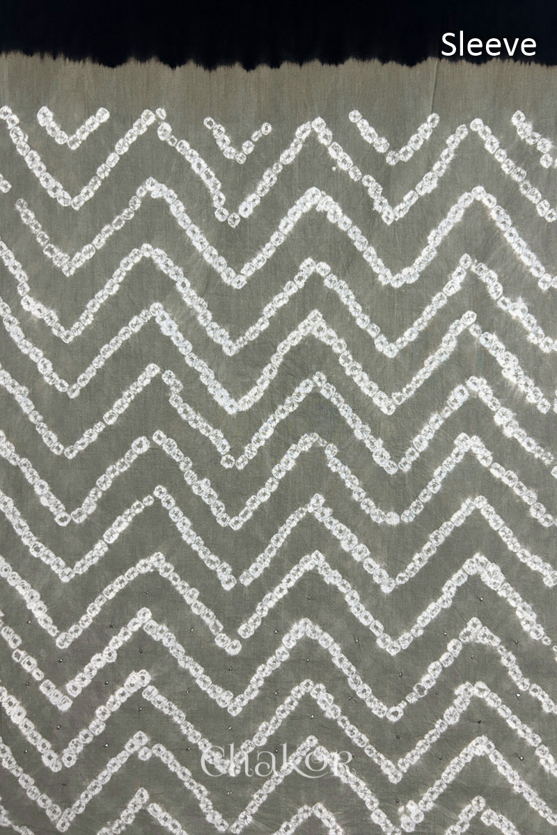 Close-up of  cement grey bandhani fabric featuring chevron tie-dye design, with Chakor brand watermark. Text reads sleeve.
