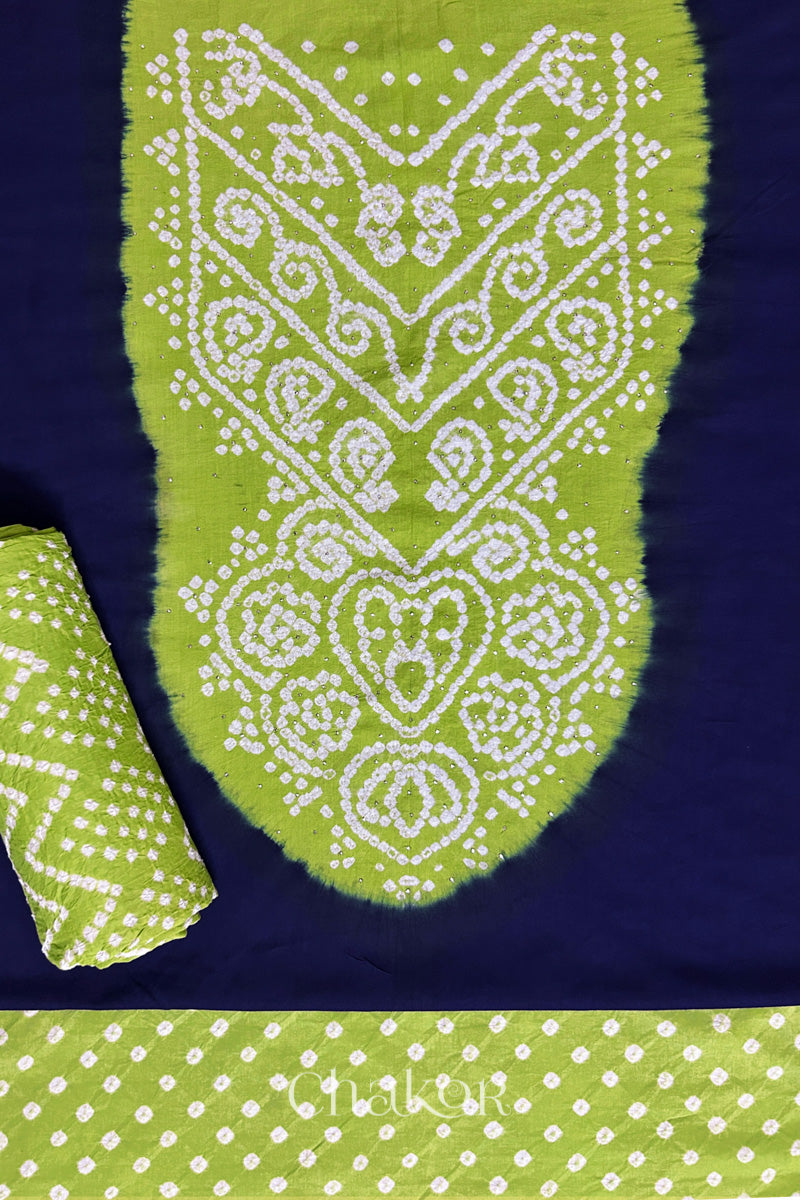 A classic navy set fabric featuring sparkly mukaish embroidered contrast lime green yoke & bottom and dupatta rolled beautifully and placed on the fabric. Text reads Chakor.
