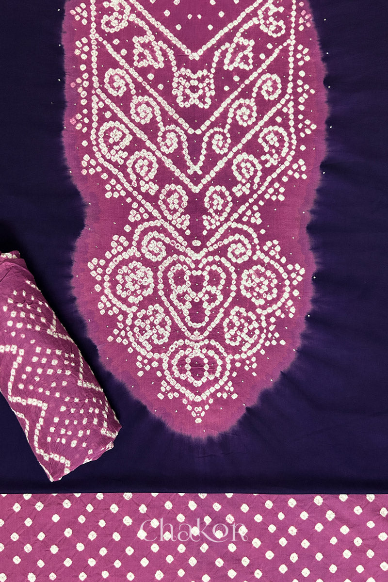 A classic dark purple set fabric featuring sparkly mukaish embroidered contrast violet puprle yoke & bottom and dupatta rolled beautifully and placed on the fabric. Text reads Chakor.
