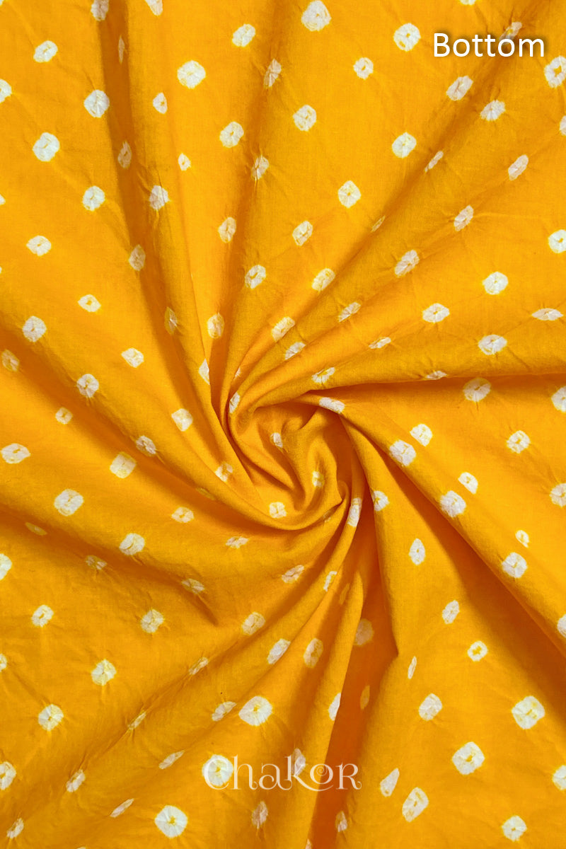 Close-up of yellow fabric featuring bandhani pattern of white dots, arranged in a swirly style showcasing the textile's texture and design details.Text reads bottom details.
