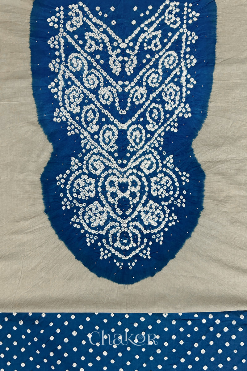 Close-up of light grey kurta fabric featuring intricate bandhani & indigo blue mukaish embroidered yoke with bandhani dotted bottom fabric, with Chakor brand watermark.
