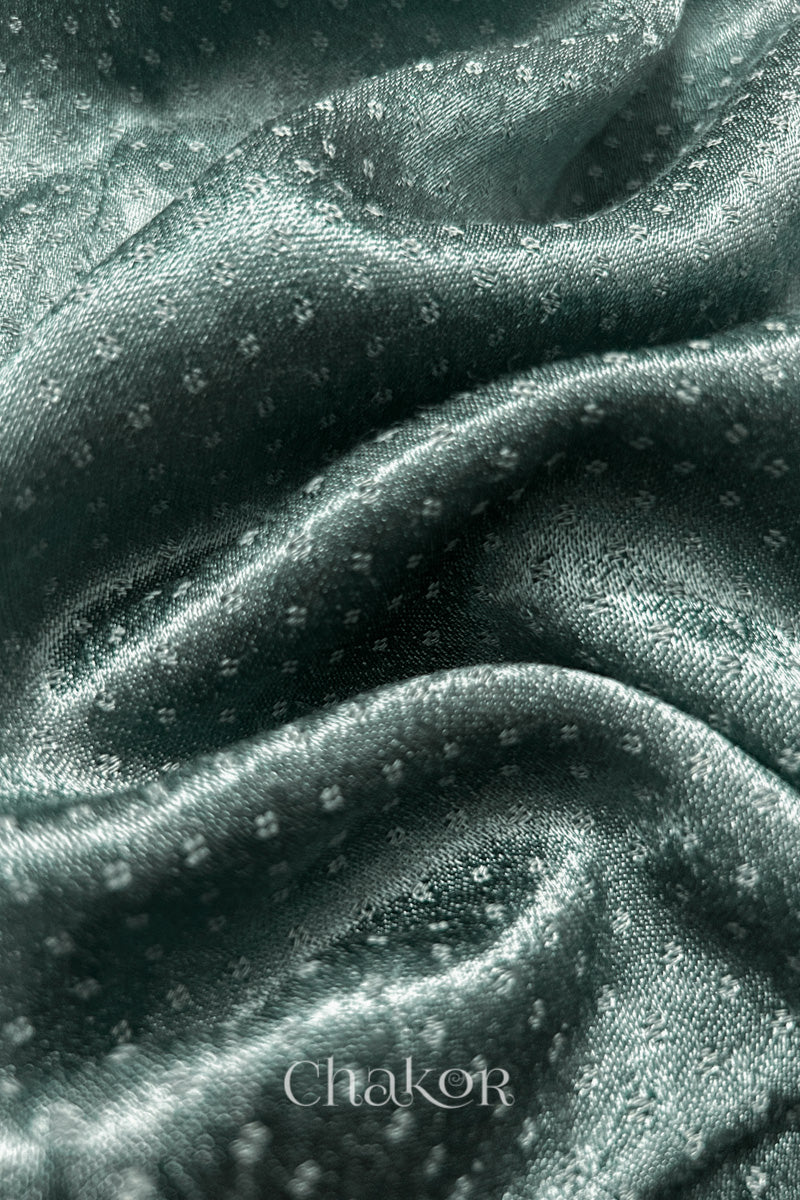 Close-up of Charcoal grey mashru self textured fabric with 'Chakor' logo visible.
