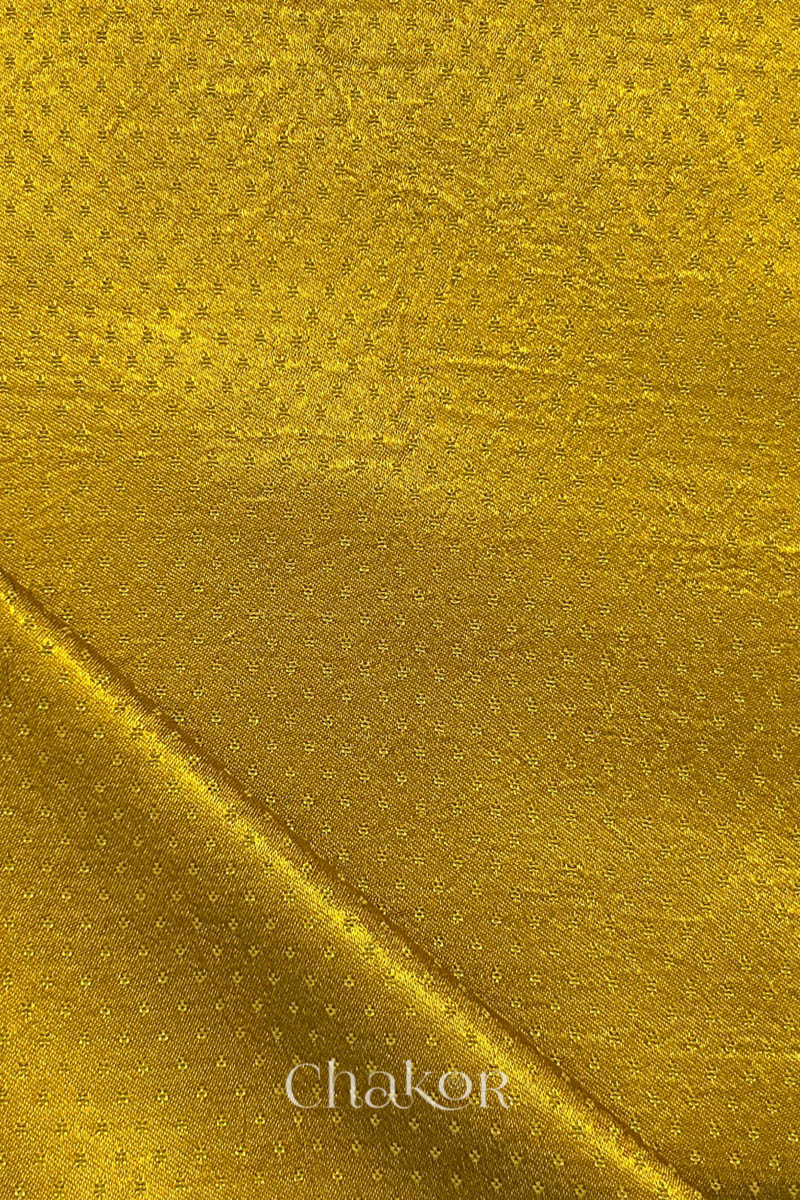 mustard yellow mashru self textured fabric with folded corner & Chakor brand watermark.

