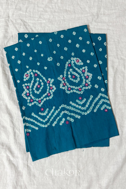 Turquoise Kutch Bandhani cotton unstitched blouse fabric with Keri pattern piece folded on white fabric.
