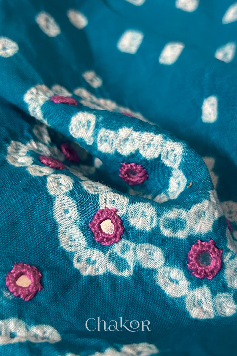 Close-up of Turquoise Kutch Bandhani blouse fabric showing Keri motifs and hand-embroidered mirror work.
