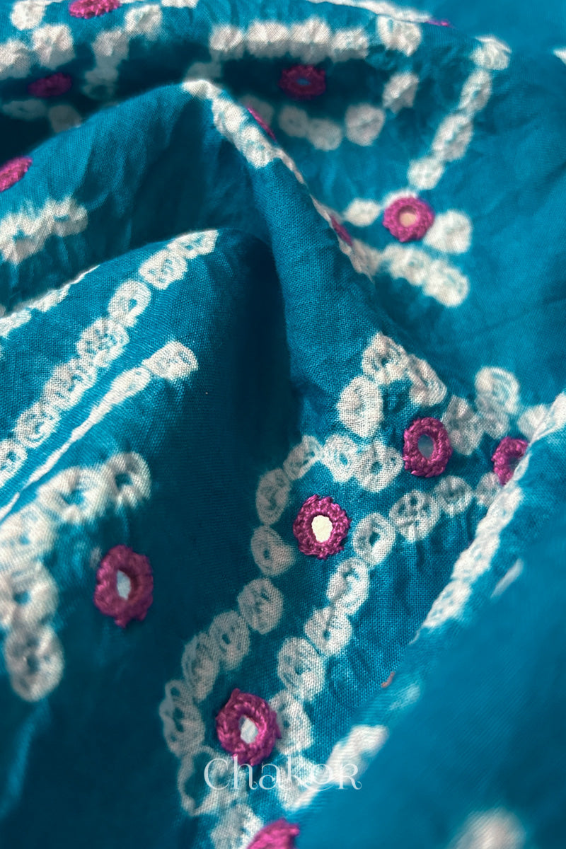 Detail of Kutch Bandhani Keri pattern with mirror embroidery on Turquoise cotton blouse fabric.

