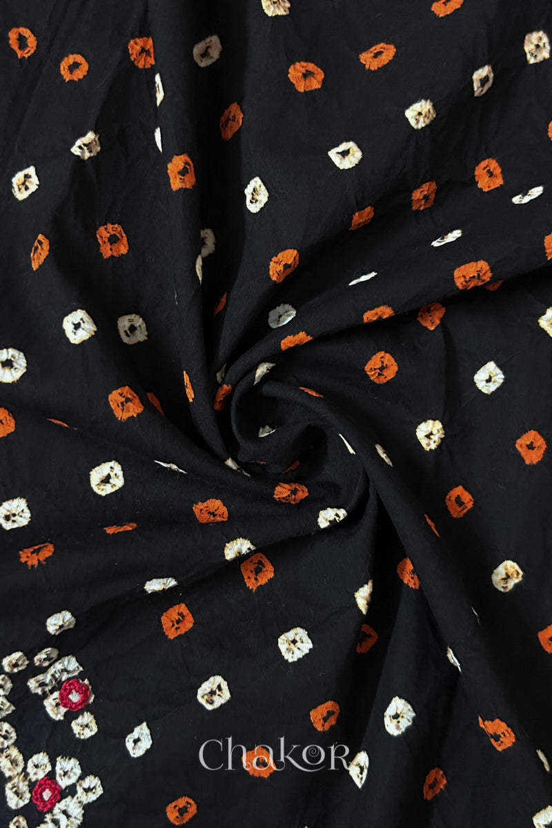 Black Bandhani cotton blouse fabric showing fine tie-dye dots and its soft drape.
