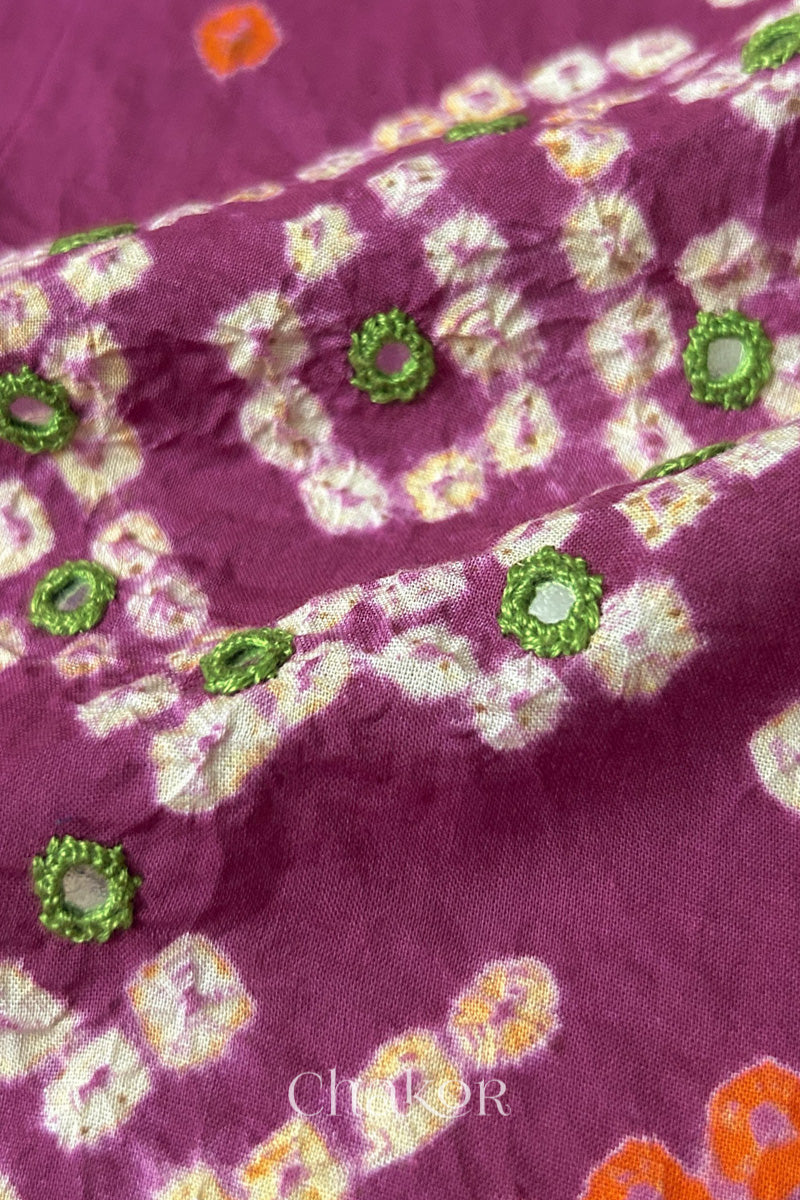 Close-up of Magenta Kutch Bandhani blouse fabric showing Keri motifs and hand-embroidered mirror work.
