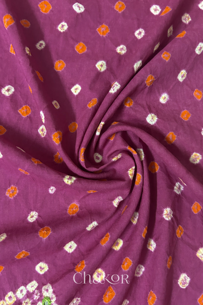 Magenta Bandhani cotton blouse fabric showing fine tie-dye dots and its soft drape.
