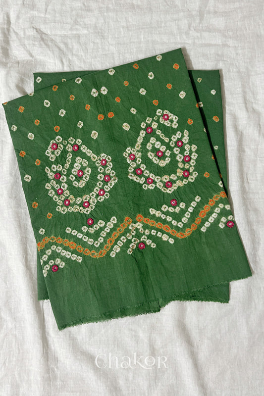 Mehendi Green Kutch Bandhani cotton unstitched blouse fabric with Keri pattern piece folded on white fabric.
