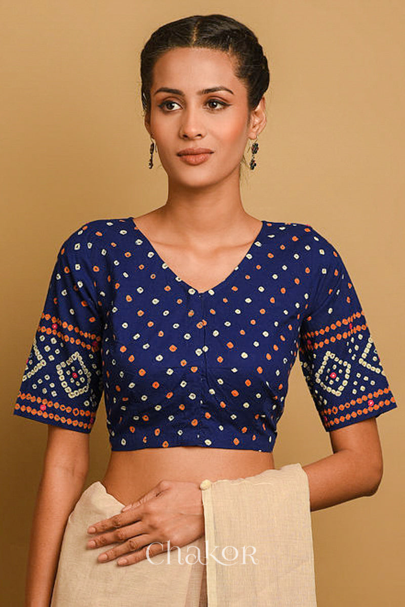 Woman wearing a handcrafted Navy blue bandhani cotton blouse in traditional patterns with mirror embroidery.