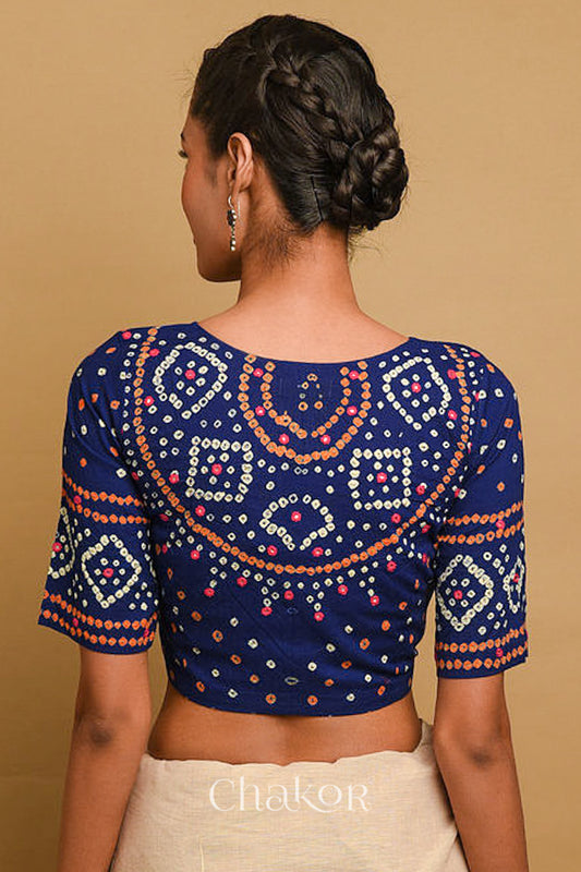 Woman wearing a handcrafted Navy blue bandhani cotton blouse in traditional patterns with mirror embroidery.