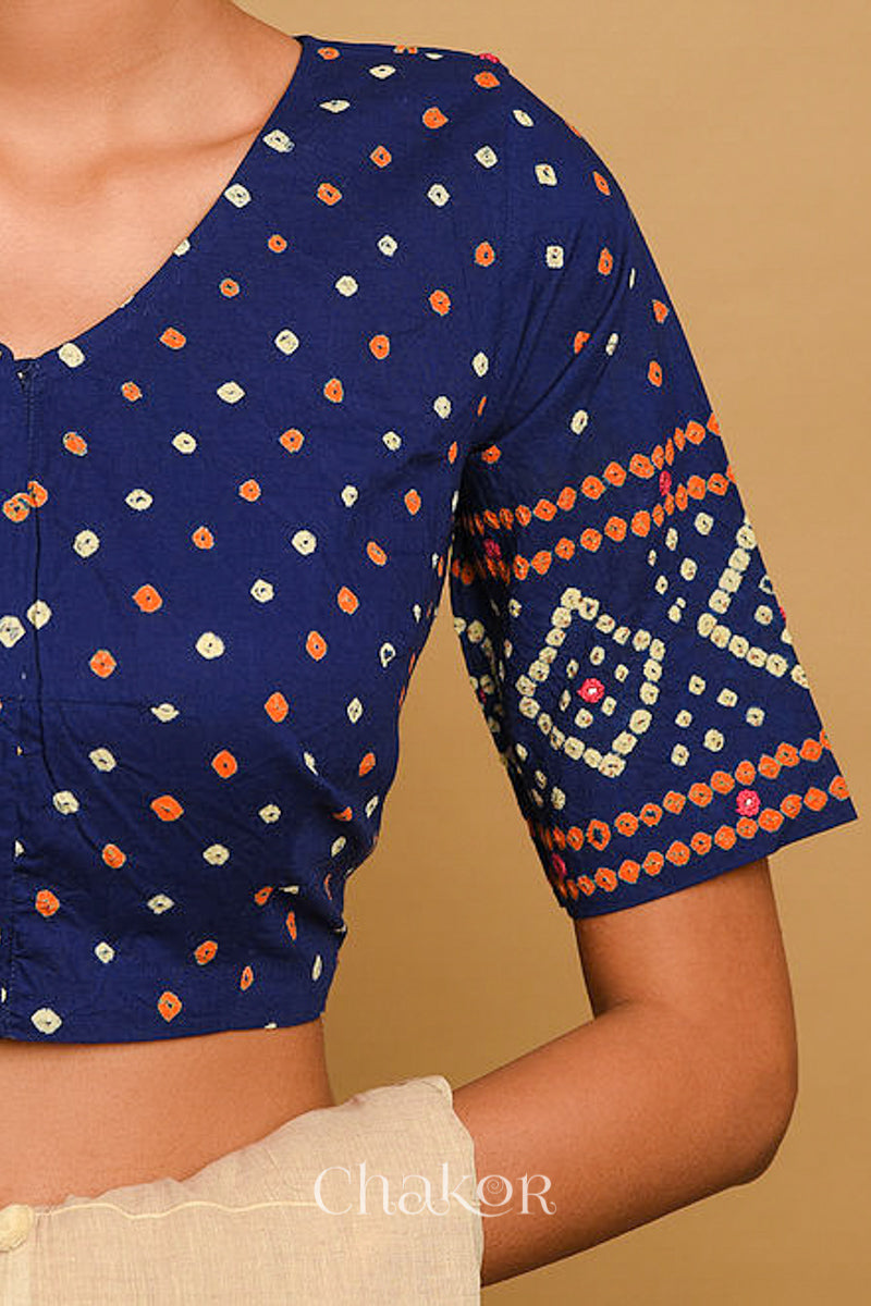 Woman wearing a handcrafted Navy blue bandhani cotton blouse in traditional patterns with mirror embroidery.