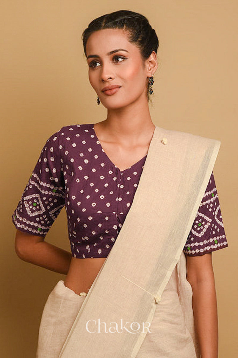 Woman wearing a handcrafted brown bandhani cotton blouse in traditional patterns with mirror embroidery.