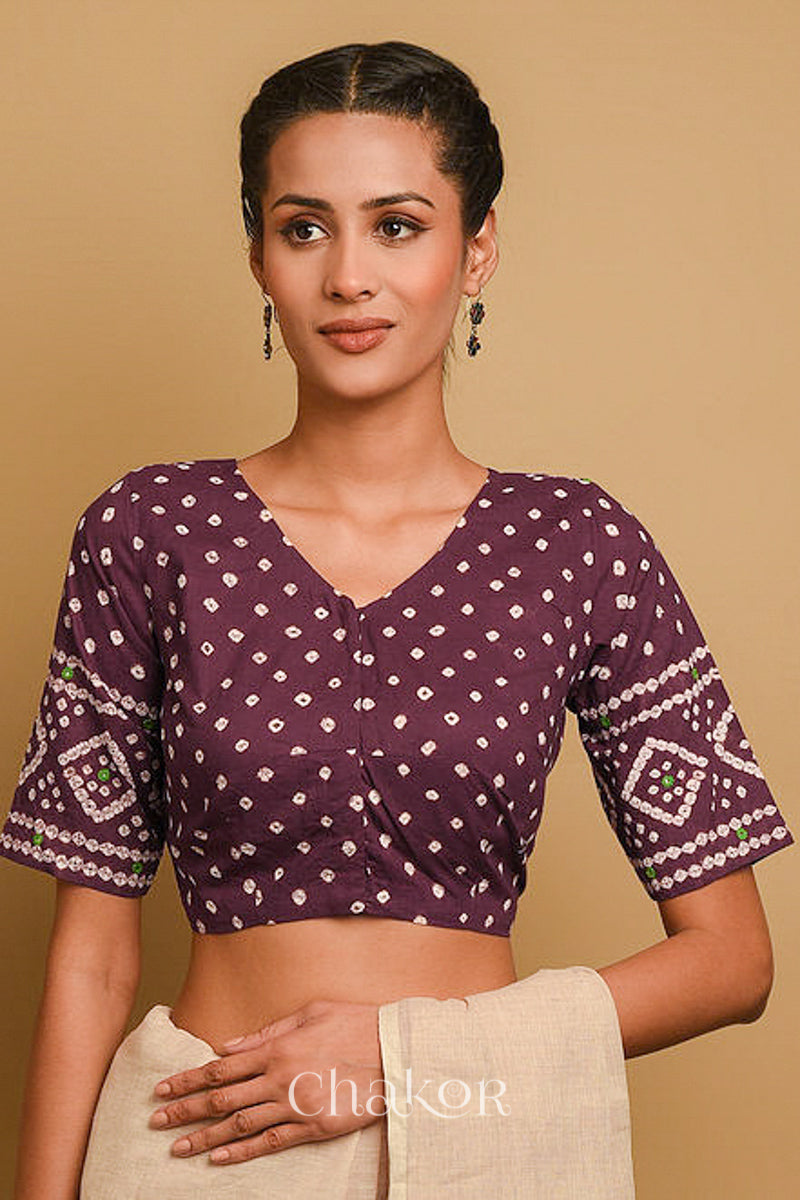 Woman wearing a handcrafted brown bandhani cotton blouse in traditional patterns with mirror embroidery.