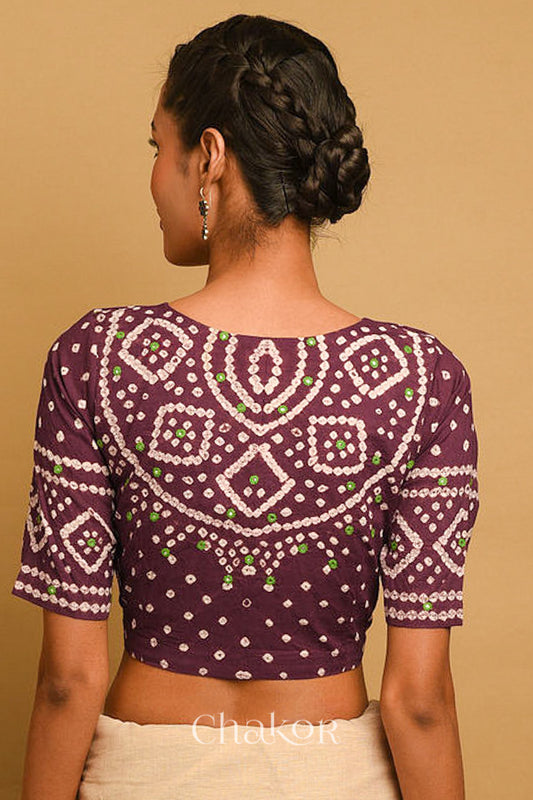 Woman wearing a handcrafted brown bandhani cotton blouse in traditional patterns with mirror embroidery.