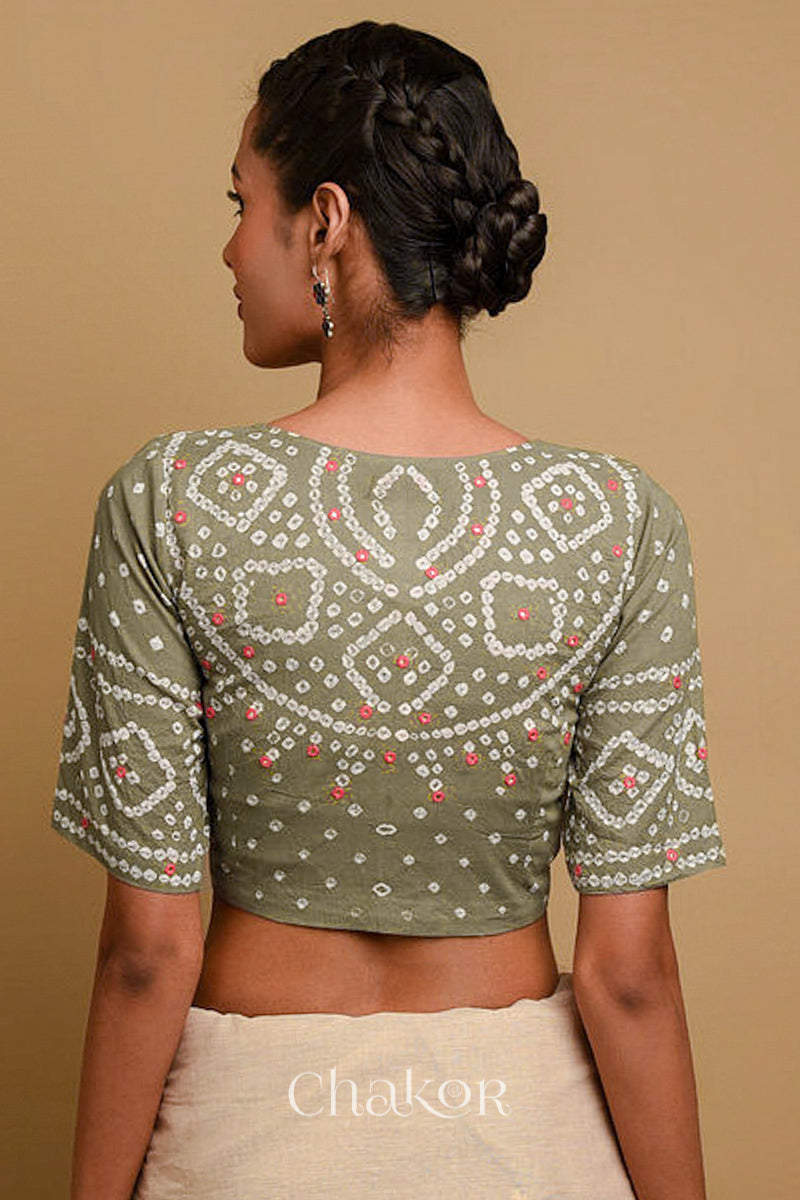 Woman wearing a handcrafted grey bandhani cotton blouse in traditional patterns with mirror embroidery.