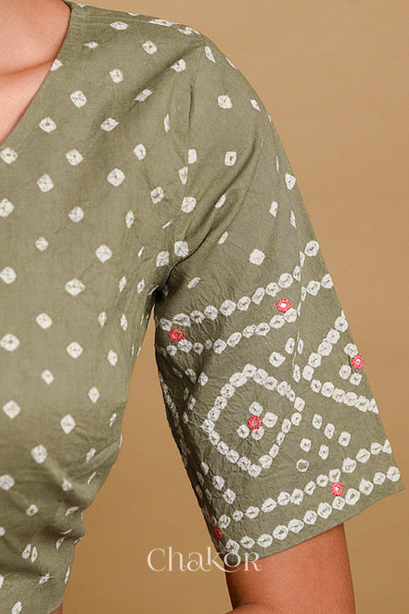 Woman wearing a handcrafted grey bandhani cotton blouse in traditional patterns with mirror embroidery.