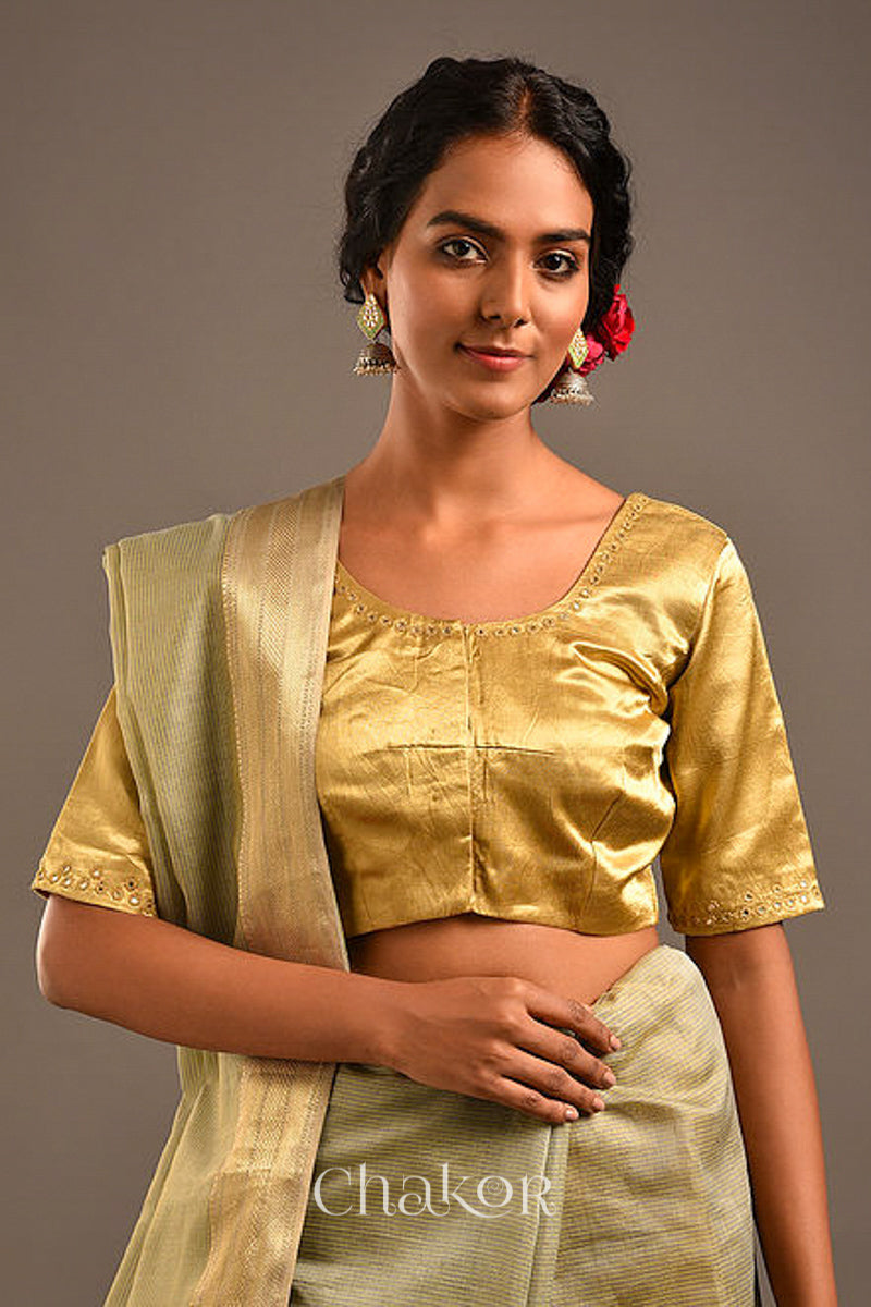 Woman wearing a handcrafted Beige Mashru Silk Blouse with intricate mirror embroidery.