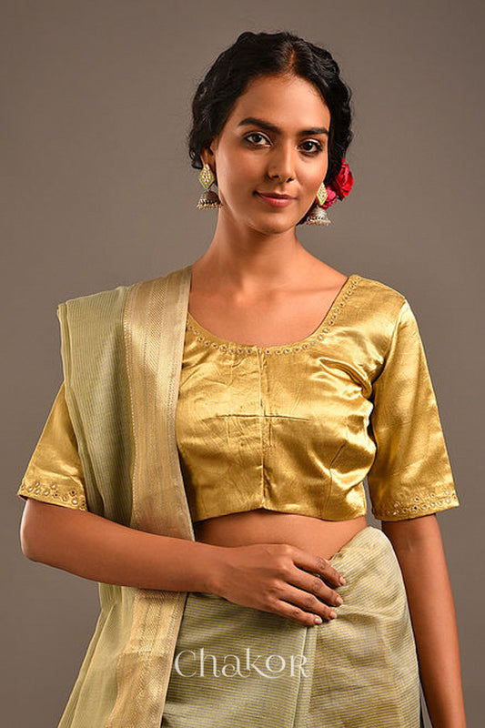 Woman wearing a handcrafted Beige Mashru Silk Blouse with intricate mirror embroidery.