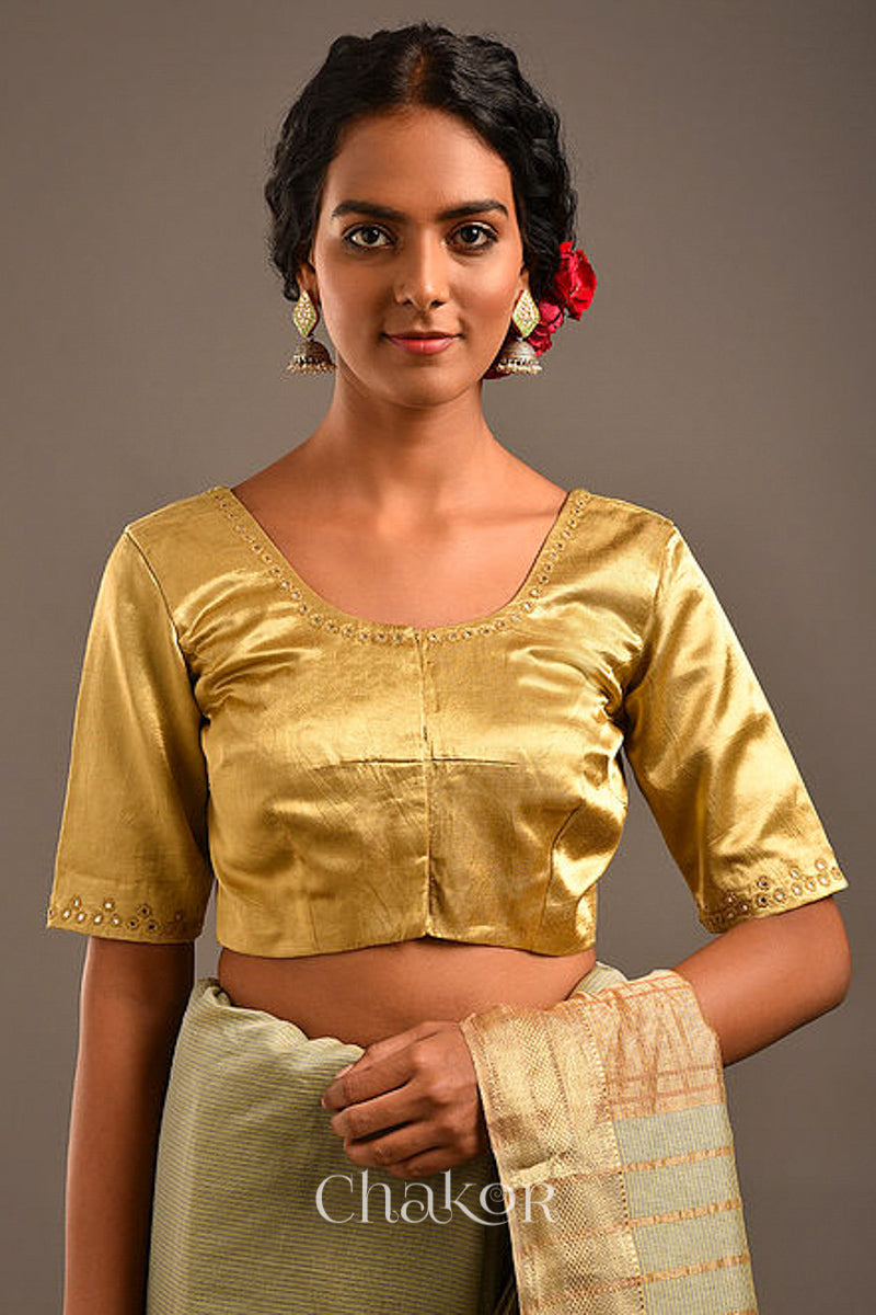 Woman wearing a handcrafted Beige Mashru Silk Blouse with intricate mirror embroidery.