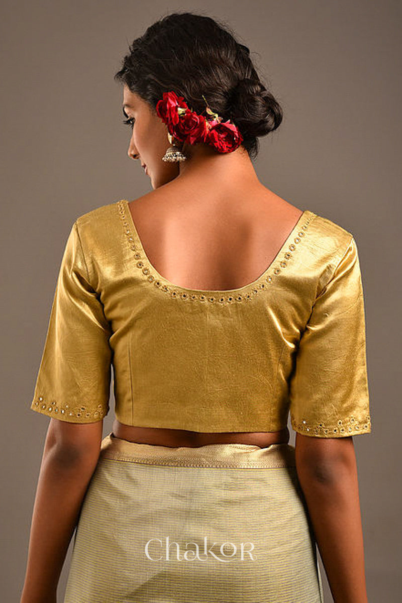 Woman wearing a handcrafted Beige Mashru Silk Blouse with intricate mirror embroidery.