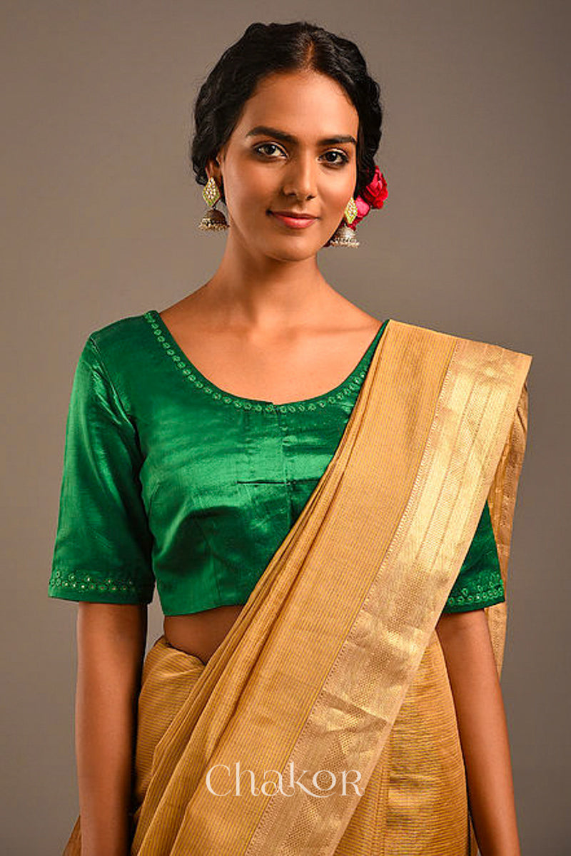 Woman wearing a handcrafted Jade Green Mashru Silk Blouse with intricate mirror embroidery.