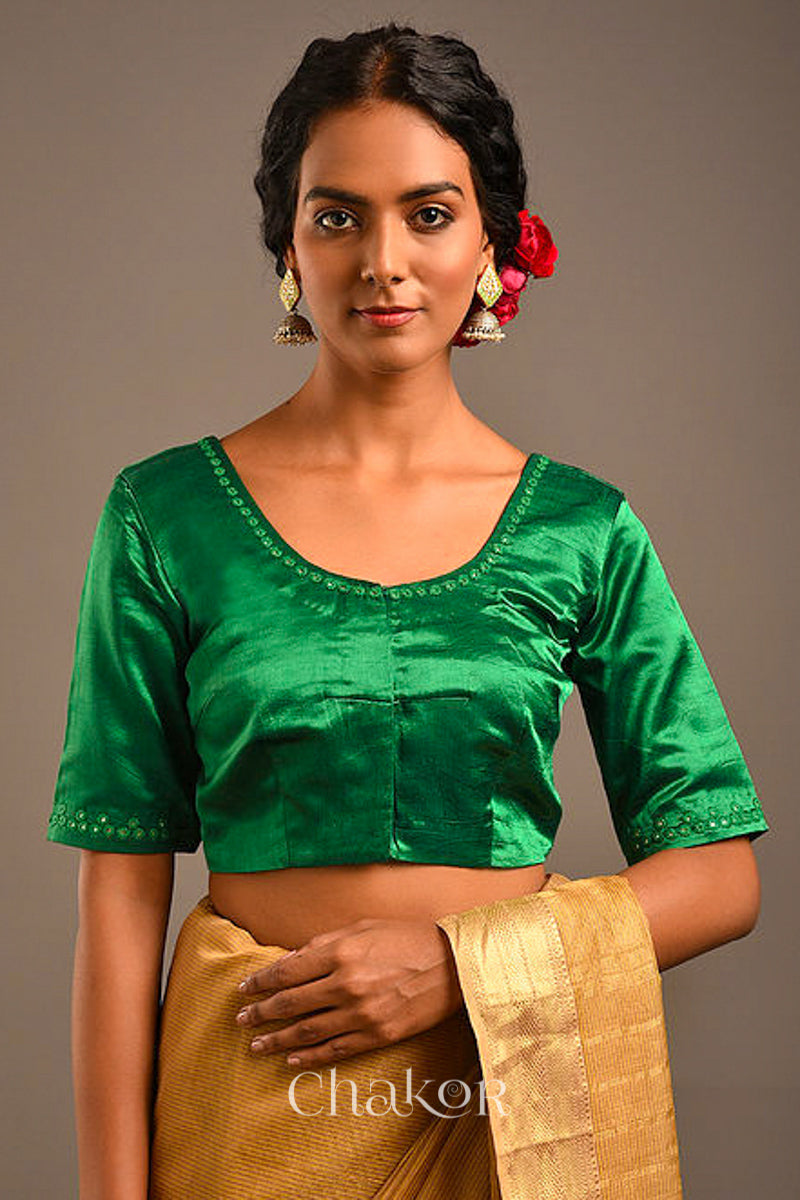 Woman wearing a handcrafted Jade green Mashru Silk Blouse with intricate mirror embroidery.