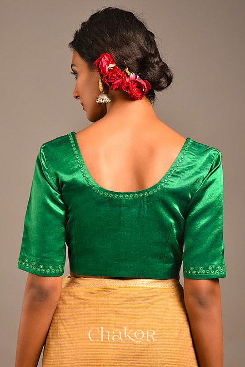 Woman wearing a handcrafted Jade green Mashru Silk Blouse with intricate mirror embroidery.