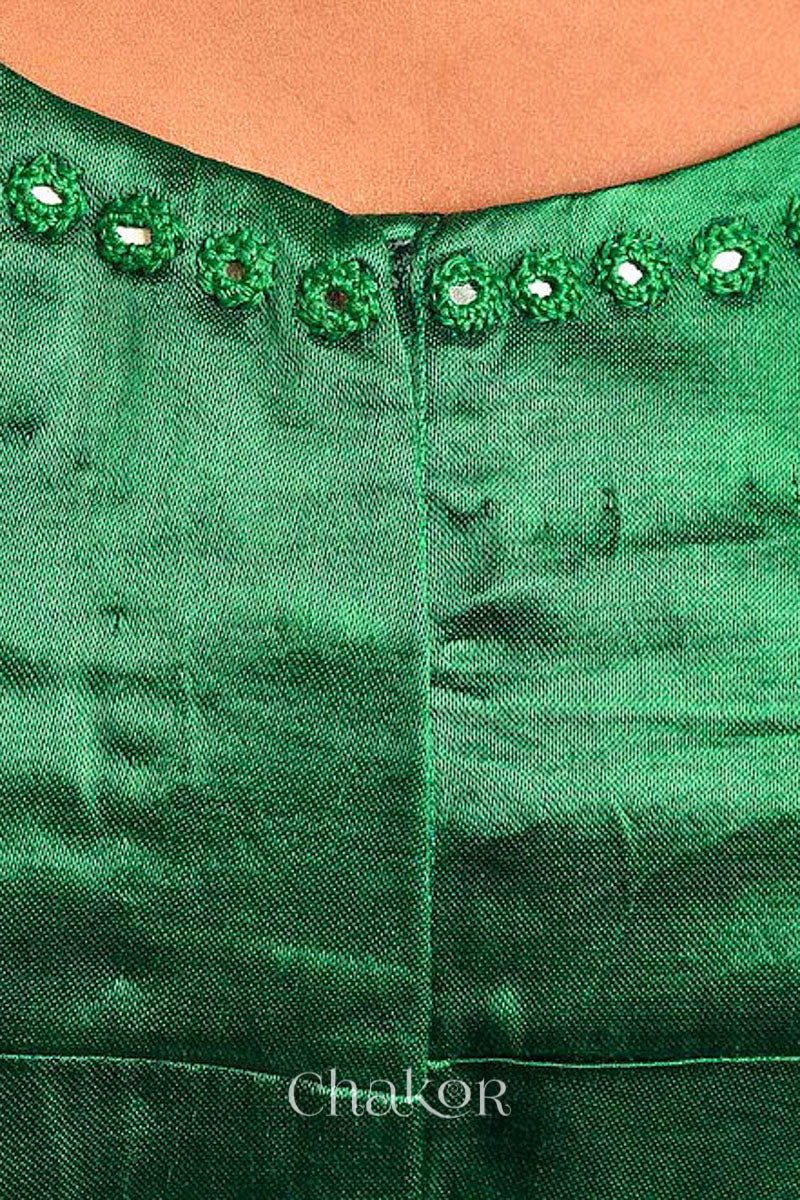 Woman wearing a handcrafted Jade green Mashru Silk Blouse with intricate mirror embroidery.