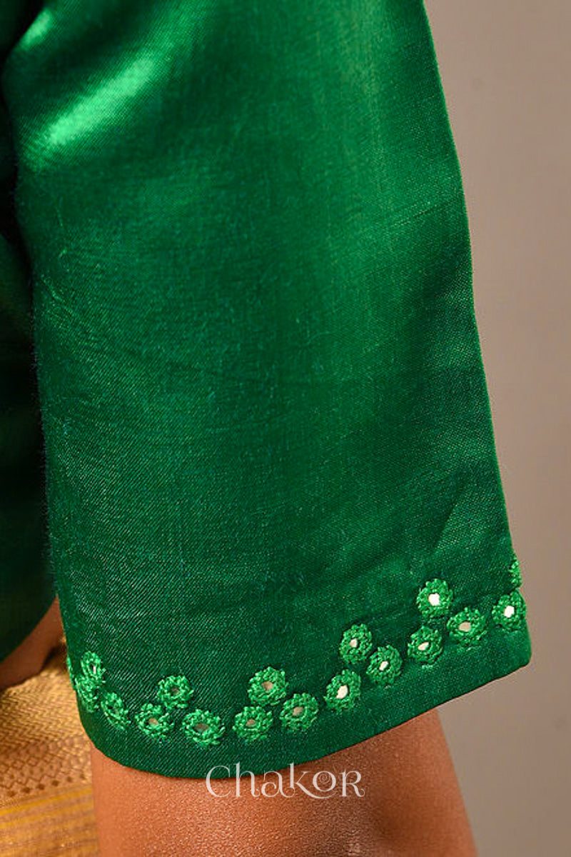 Woman wearing a handcrafted Jade green Mashru Silk Blouse with intricate mirror embroidery.