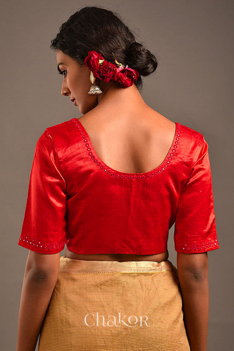 Woman wearing a handcrafted Red Mashru Silk Blouse with intricate mirror embroidery.