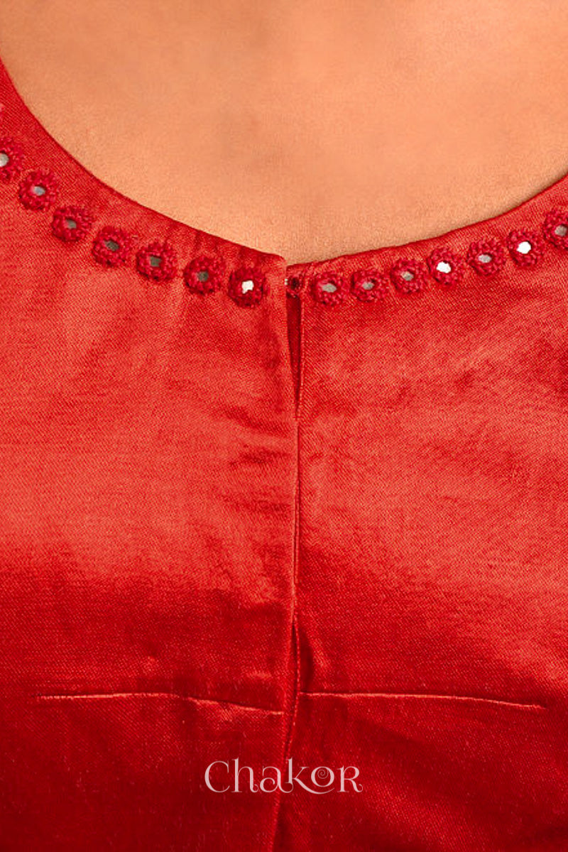 Woman wearing a handcrafted Red Mashru Silk Blouse with intricate mirror embroidery.
