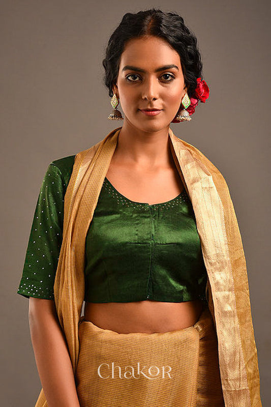 Woman wearing a handcrafted green Mashru Silk Blouse with mukaish embroidery.
