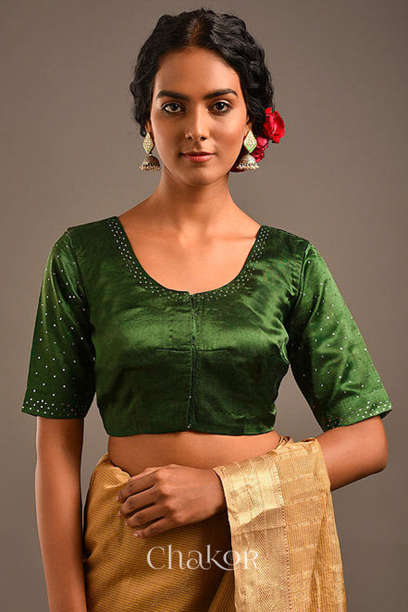 Woman wearing a handcrafted green Mashru Silk Blouse with mukaish embroidery.