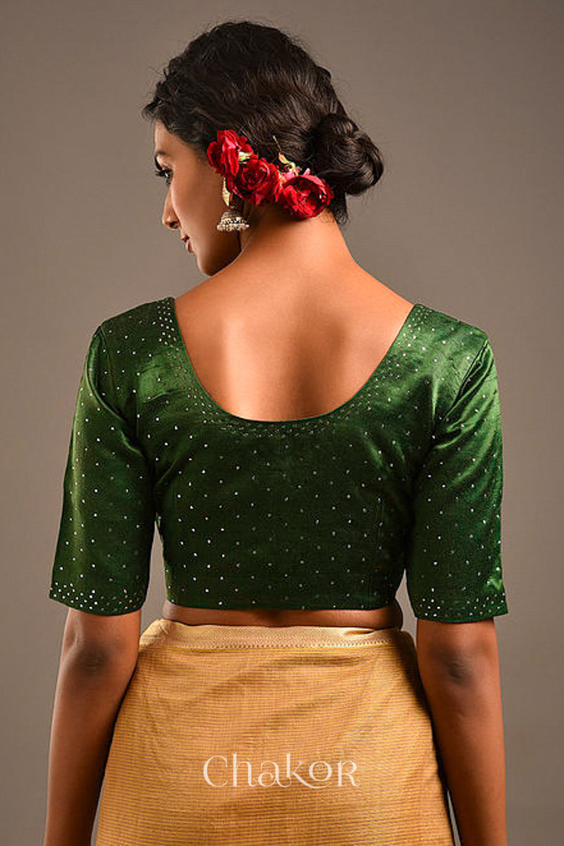 Woman wearing a handcrafted green Mashru Silk Blouse with mukaish embroidery.