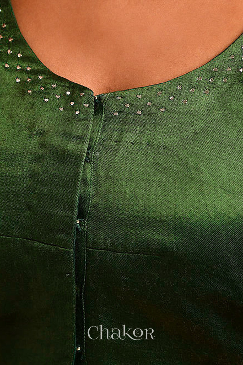 Woman wearing a handcrafted green Mashru Silk Blouse with mukaish embroidery.