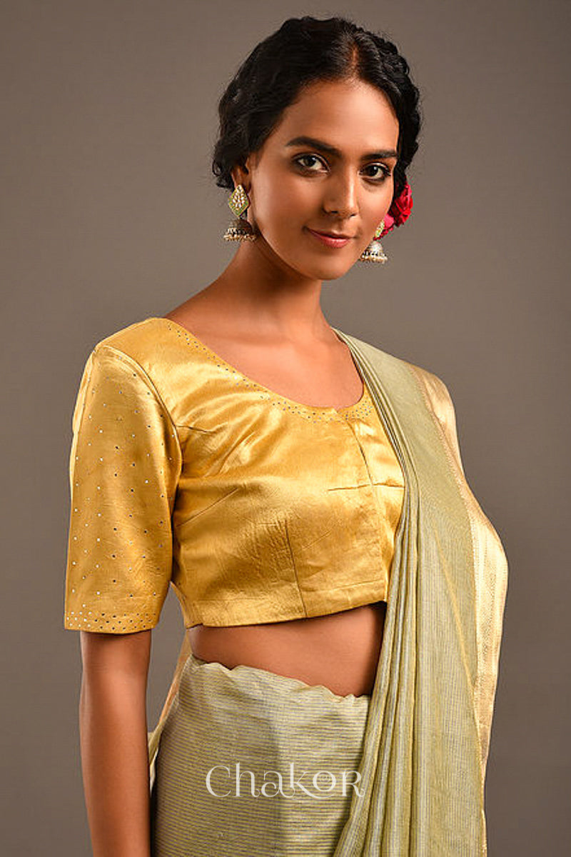 Woman wearing a handcrafted gold Mashru Silk Blouse with mukaish embroidery.
