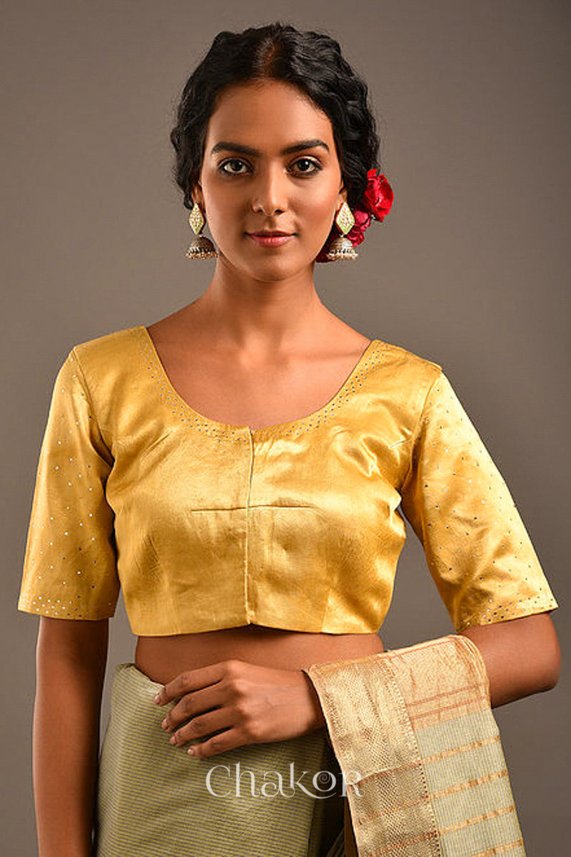 Woman wearing a handcrafted gold Mashru Silk Blouse with mukaish embroidery.